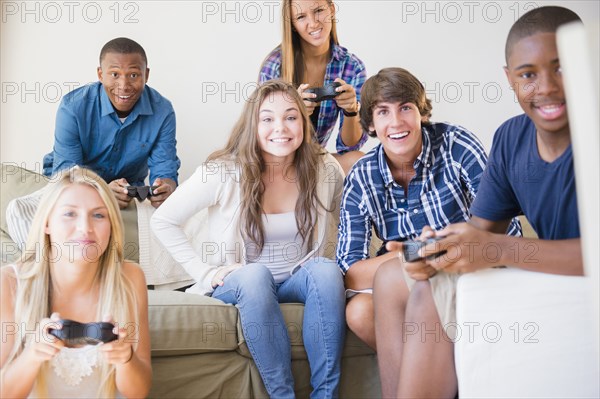 Teenagers playing video games in living room