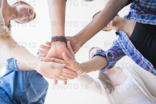 Close up of teenagers stacking hands in huddle