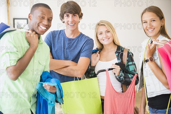 Smiling teenagers holding shopping bags