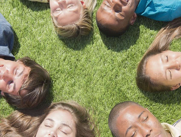 High angle view of teenagers sleeping on grass lawn