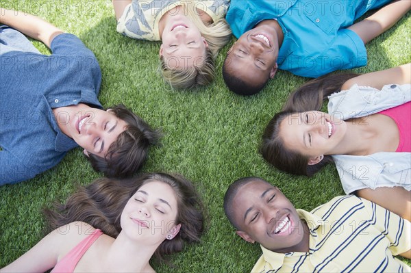 High angle view of teenagers laying on grass lawn