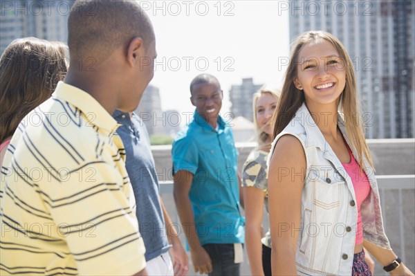 Smiling teenagers walking on urban rooftop