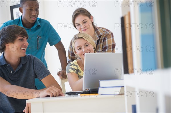 Teenagers using laptop at desk