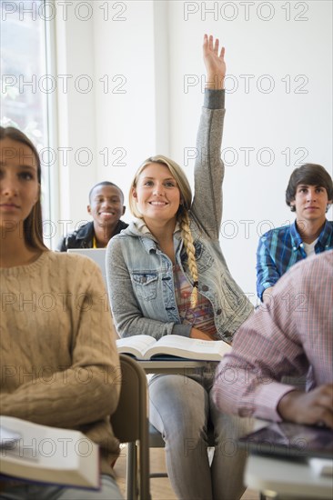 Teenage student raising hand in classroom