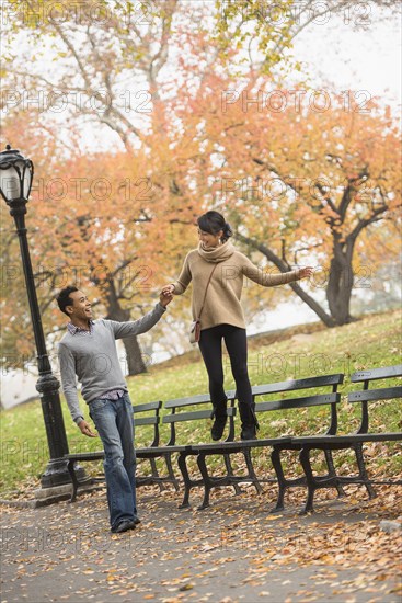 Couple playing on park bench