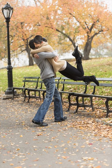 Smiling couple hugging in park