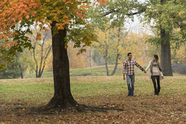 Couple holding hands and walking in park