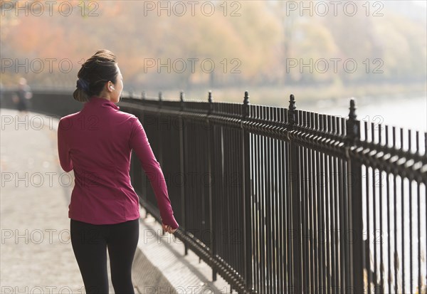 Asian woman running on waterfront path