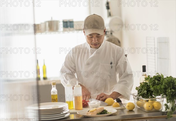 Korean chef slicing food in kitchen