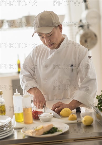 Korean chef slicing food in kitchen