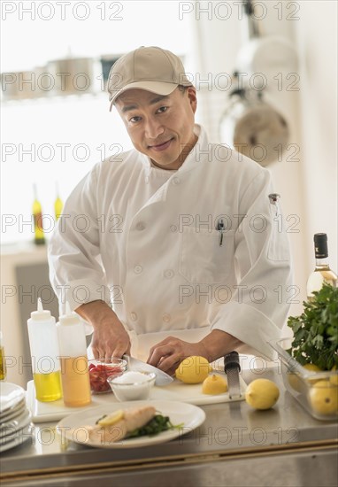 Korean chef slicing food in kitchen