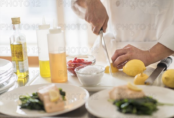 Korean chef slicing lemons in kitchen