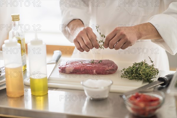 Korean chef seasoning meat in kitchen