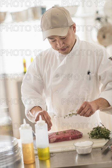 Korean chef seasoning meat in kitchen