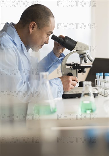 Korean scientist using microscope in laboratory