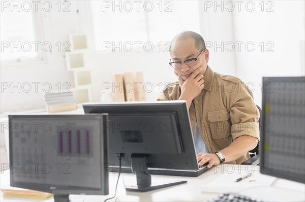 Korean businessman working on computer at office desk