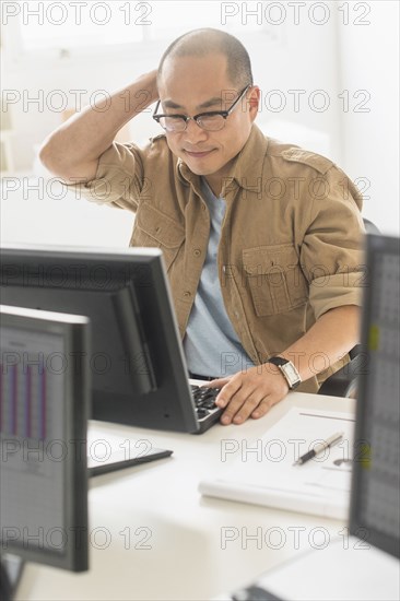 Korean businessman working on computer at office desk