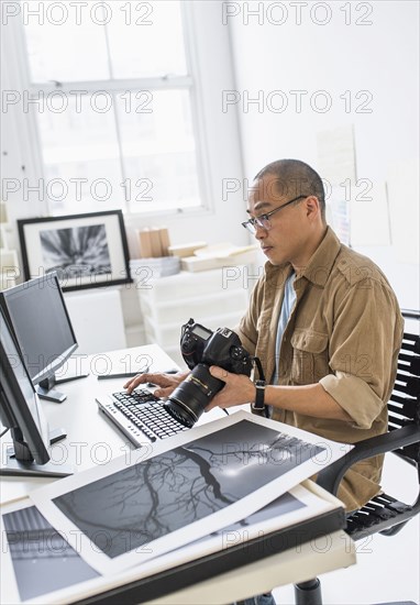 Korean photographer using computer at desk