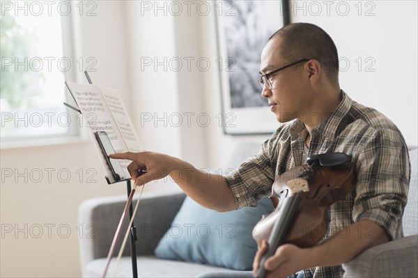 Korean musician using cell phone in living room