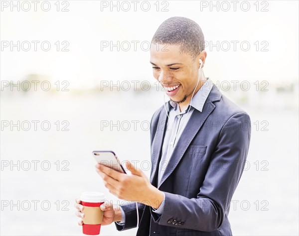 Black businessman using cell phone outdoors