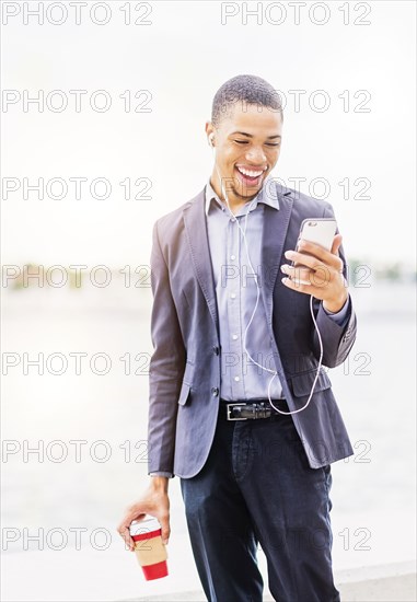 Black businessman using cell phone outdoors