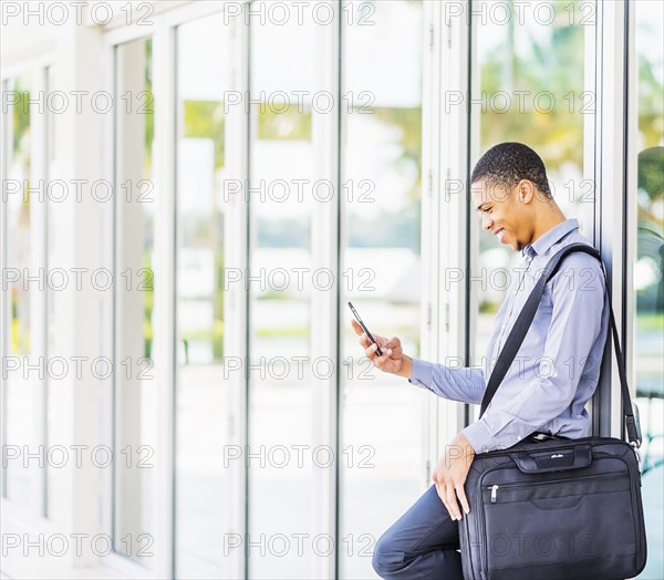 Black businessman using cell phone outdoors