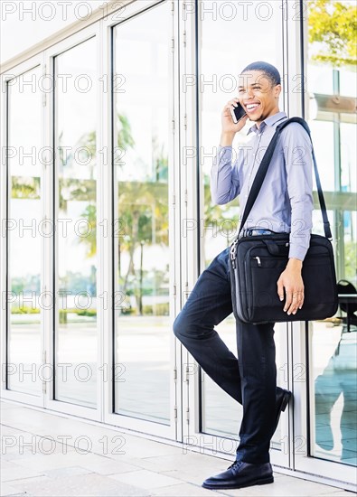 Black businessman talking on cell phone outdoors