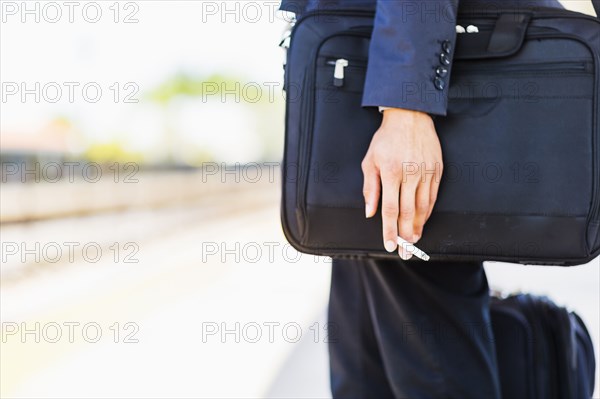 Black businessman holding cigarette outdoors