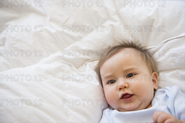 Close up of mixed race baby laying on bed