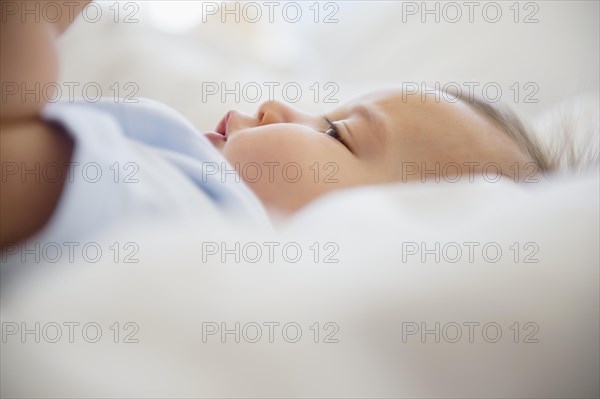 Close up of mixed race baby laying on bed