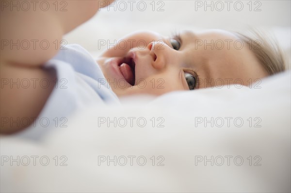 Close up of mixed race baby laying on bed