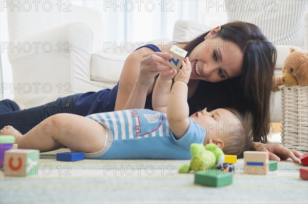 Mixed race mother playing with baby on floor