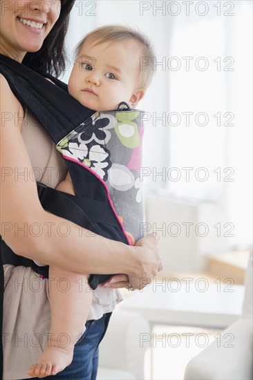 Mixed race mother carrying baby in baby carrier