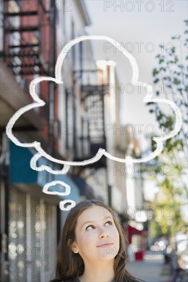 Caucasian woman looking up at thought bubble