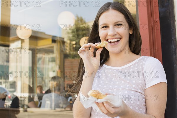 Caucasian woman eating outside cafe