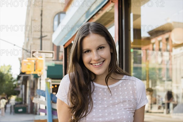 Caucasian woman smiling on urban sidewalk