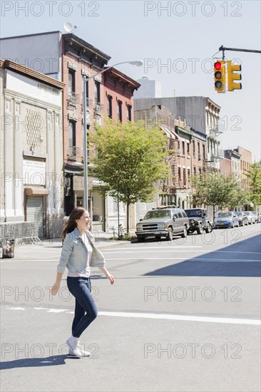 Caucasian woman crossing urban street