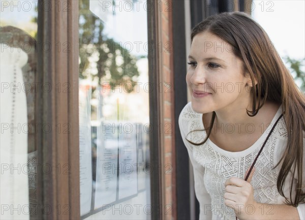 Caucasian woman window shopping outside store