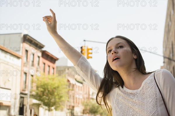 Caucasian woman hailing taxi in city