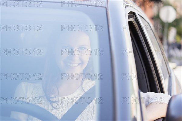 Caucasian woman smiling in car
