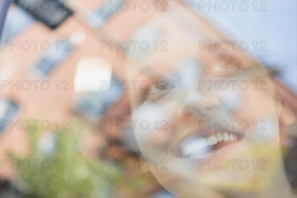 Caucasian woman and reflection of apartment buildings in window