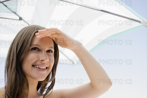 Caucasian woman shielding her eyes from sun