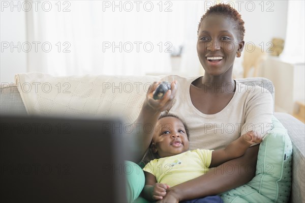 Black mother and son playing on sofa