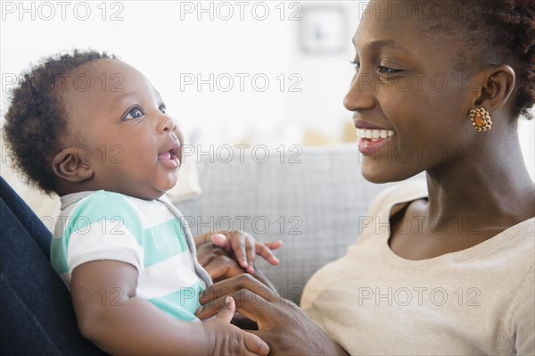 Black mother and son playing on sofa