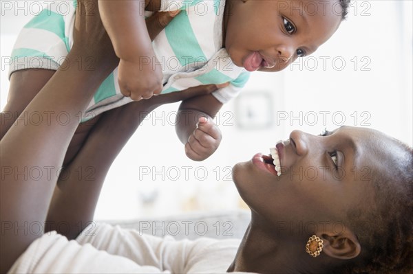 Black mother and son playing on sofa