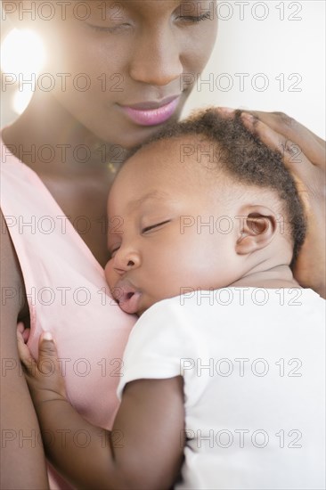 Black mother holding sleeping son