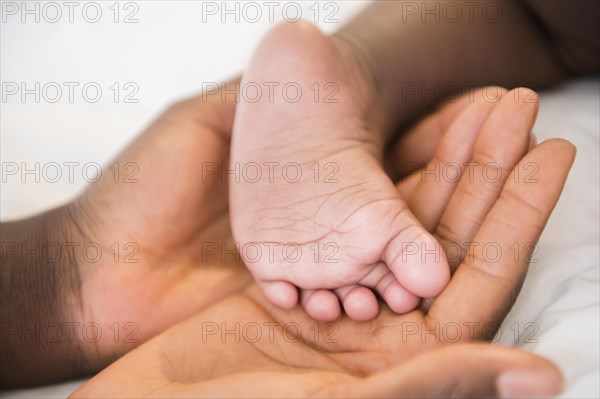 Close up of Black mother holding foot of baby