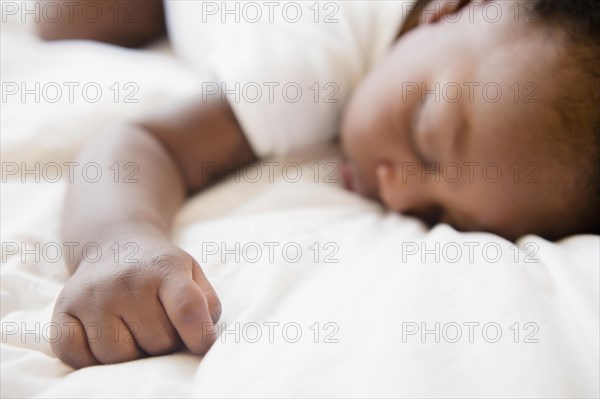 Close up of Black baby boy sleeping on bed