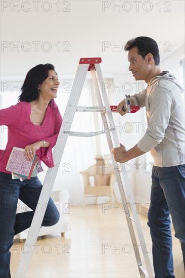 Couple talking at ladder during home remodeling