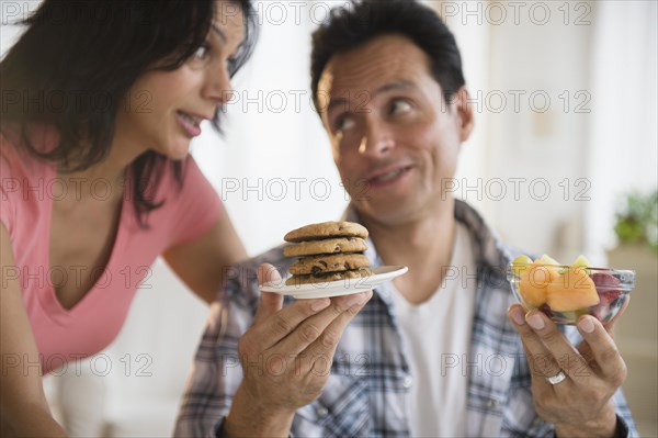 Couple choosing between healthy and unhealthy snacks